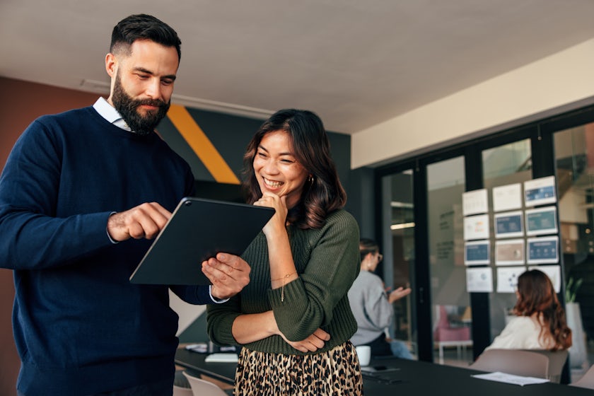 A man and a woman looking at a tablet