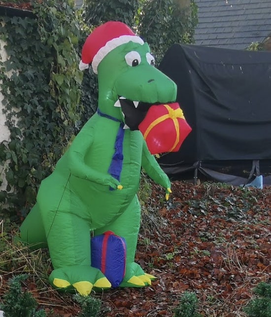 Inflatable dinosaur with a Christmas hat and gift