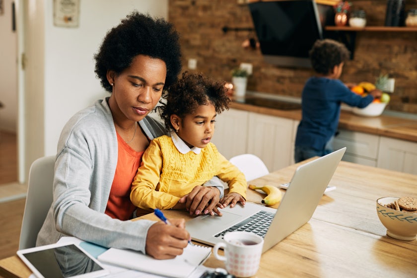 Mother with two kids working at laptop